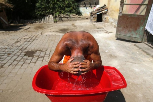 A Roma man cools himself in the impoverished outskirts of Ozd, northeastern Hungary, in the grip of a heat wave, Aug. 7, 2013. REUTERS/Laszlo Balogh 