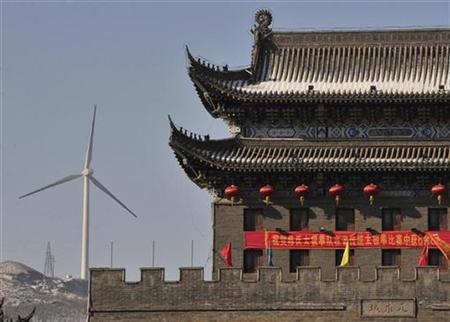 A wind turbine is seen near a gate of the ancient city of Wushu in Diaobingshan, Liaoning province January 18, 2011.  REUTERS/Sheng Li
